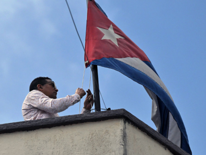 TOPSHOT - An employees of the Cuban embassy in Quito lowers the Cuban national flag, on Ma