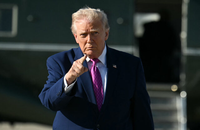 US President Donald Trump gestures after stepping off Marine One at Joint Base Andrews, Ma