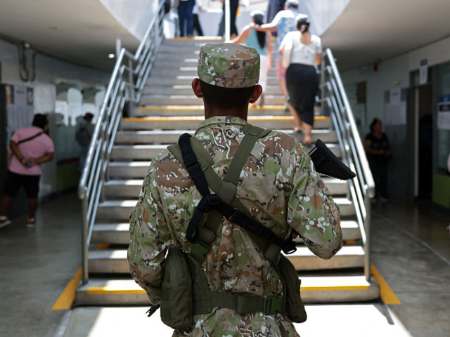 A member of the Armed Forces stands guard at the school where Peru's presidential candidat