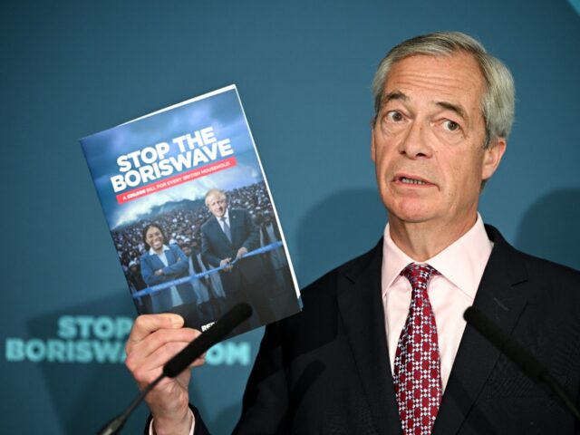 LONDON, ENGLAND - APRIL 13: Reform UK leader Nigel Farage holds a copy of a newly commissi