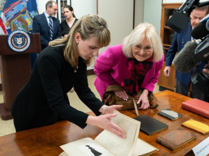 Manhattan DA antiquities trafficking analyst Hilary Chasse gently turns a page from a boun