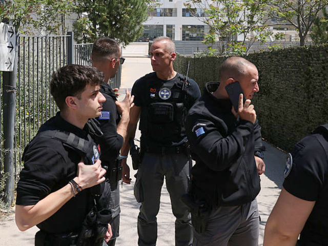 ATHENS, GREECE - APRIL 28: Police officers stand guard at the entrance of a courthouse aft