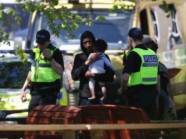 CREWE, ENGLAND - APRIL 29: Police escort parents and children out of the main building of