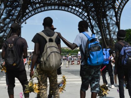 Hundreds of illegales vendors gather around of Eiffel Tower in Paris awaiting for tourists