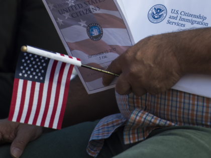 A new US citizen holds an information packet at a naturalization ceremony at Alexandria Ci