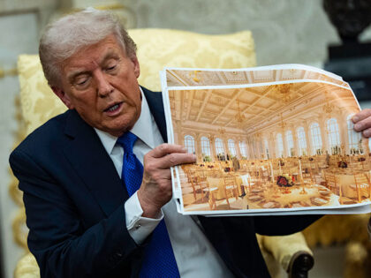 U.S. President Donald Trump speaks holding a photos of the new ballroom during a meeting w