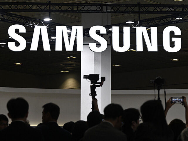 Visitors walk past the logo of Samsung Electronics during the 2026 World IT Show in Seoul