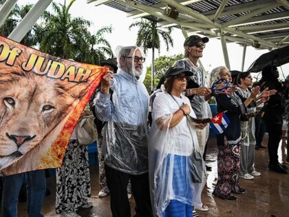 People take shelter from the rain during a "Free Cuba" rally in Miami, Florida, on April 2