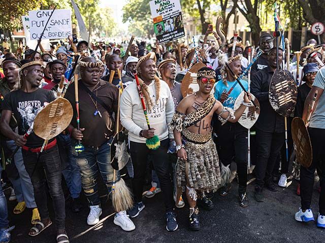Protesters chant slogans and gesture during a protest march against undocumented migrants