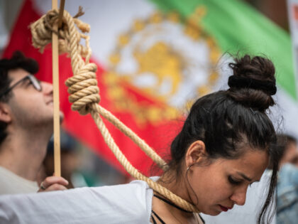 A woman simulating an execution on the gallows during a gathering outside the US Embassy o