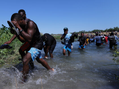 Migrants cross the Rio Grande on September 19, 2021 in Ciudad Acuña, Mexico. The makeshif