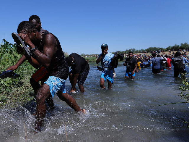 Migrants cross the Rio Grande on September 19, 2021 in Ciudad Acuña, Mexico. The makeshif