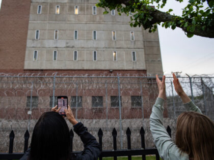 Demonstrators cheer on prisoners in the windows as they picket for the release of immigran