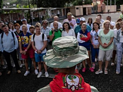 A group of Russian tourists listens to a member of the Bolivarian militia at the mausoleum