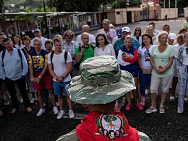 A group of Russian tourists listens to a member of the Bolivarian militia at the mausoleum