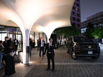 Secret Service officers and guests wait outside the Washington Hilton after shots were hea