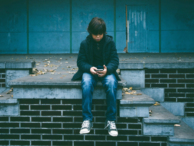 boy on stairs with phone