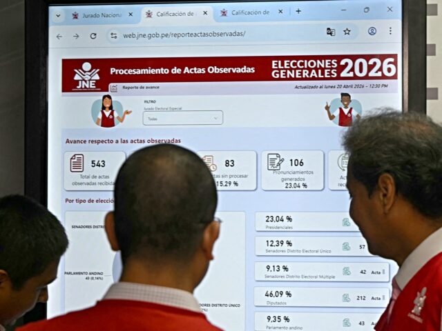 Jorge Valdivia (R), spokeperson of the National Elections Jury, looks at a screen explaini