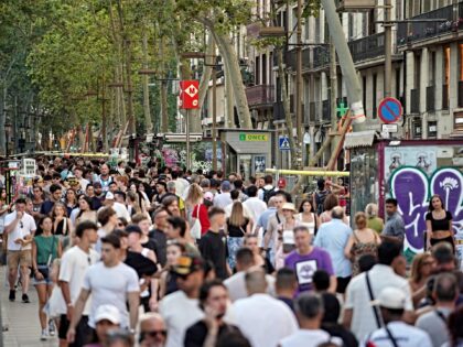 Crowds of people walk along Barcelona’s popular tourist boulevard La Rambla on August 2,