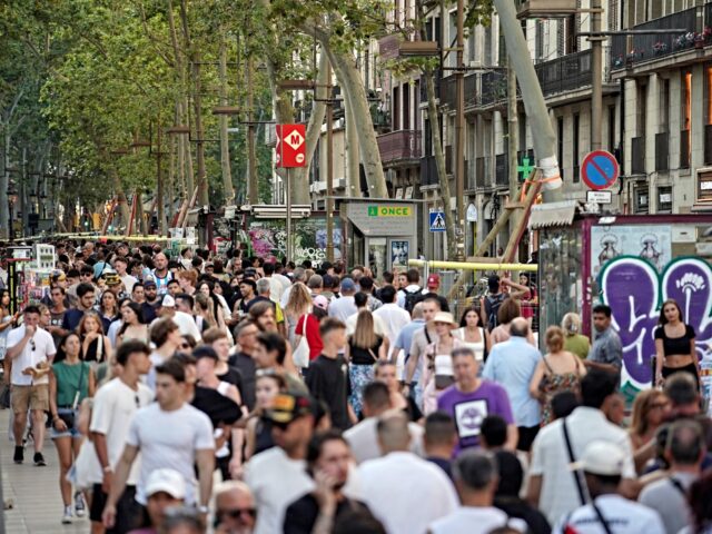 Crowds of people walk along Barcelona’s popular tourist boulevard La Rambla on August 2,