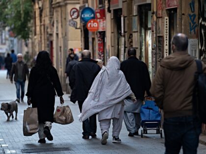 ARCELONA, CATALONIA, SPAIN - JANUARY 24: Several people walk loaded down a street, on 24 J