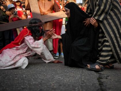 A devotee playing the role of the Virgin Mary offers her hand to a penitent depicting the