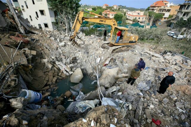 An excavator clears the rubble from the site of an overnight Israeli strike that targeted