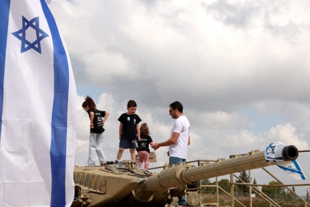 Children climb atop old tanks at the Israeli Armoured Corps memorial in Latrun, between Je