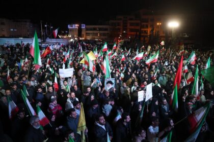 Iranians react after a ceasefire announcement at the Enqelab square in Tehran