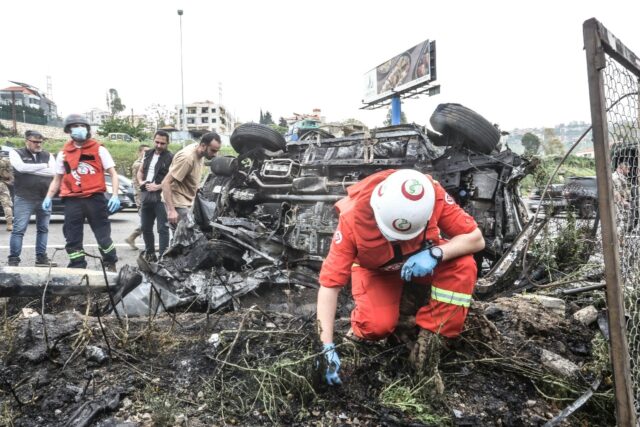 First responders inspect the site of an Israeli strike on a vehicle in the Lebanese town o