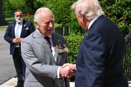 US President Donald Trump shakes hands with Britain's King Charles III as he hosts hi