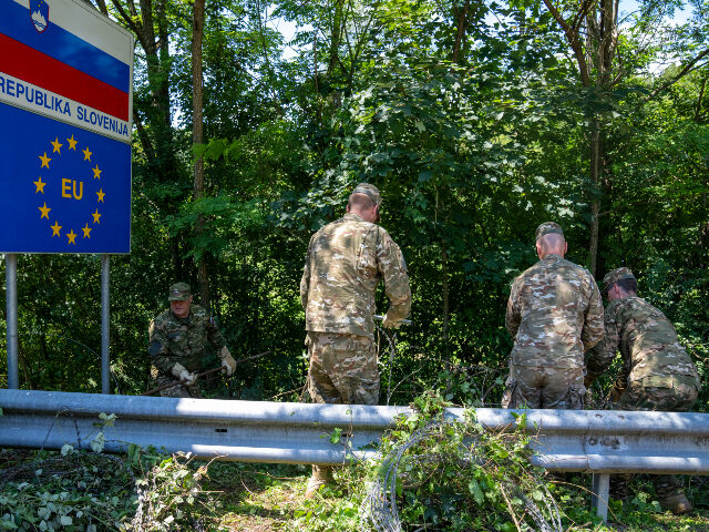 FILE - Slovenian soldiers deployed for the removal of border fence remove razor wire at th