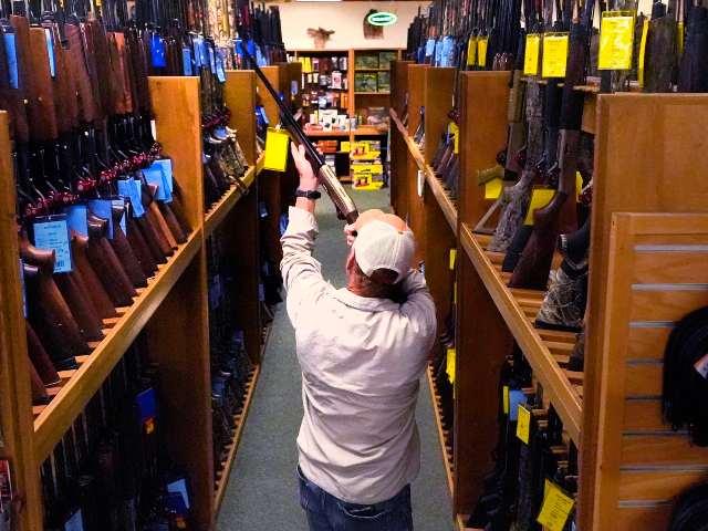 A customer sights in a long gun while shopping at the Kittery Trading Post, Friday, Aug. 9