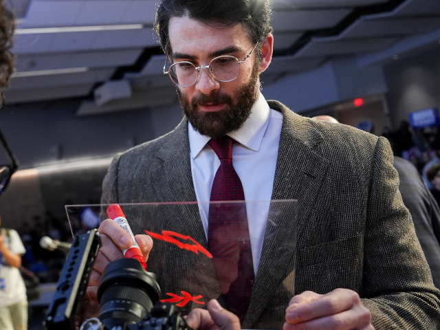 AP26099122285054 Streamer Hasan Piker signs a panel in front of a camera lens during a campaign event for A