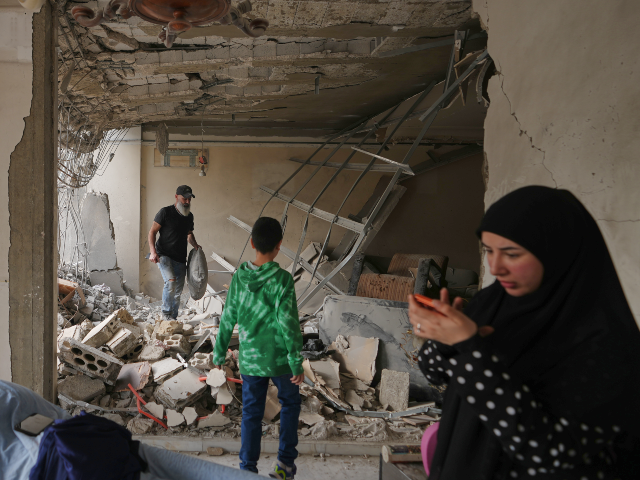 FILE - Fadi Al Zein, left, who lost both his homes in Israeli strikes in his village of Kh