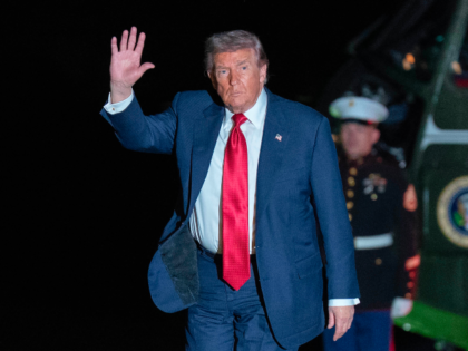 President Donald Trump waves to reporters as he walks on the South Lawn upon his arrival t
