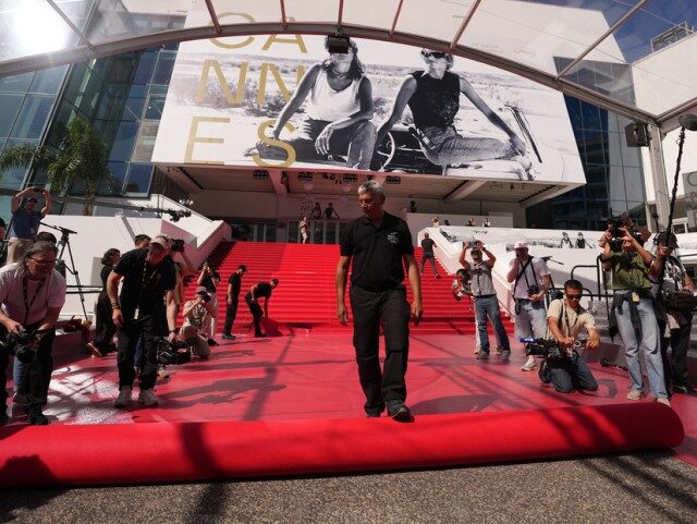 Crew members install the red carpet at the Palais des Festivals ahead of the opening cerem