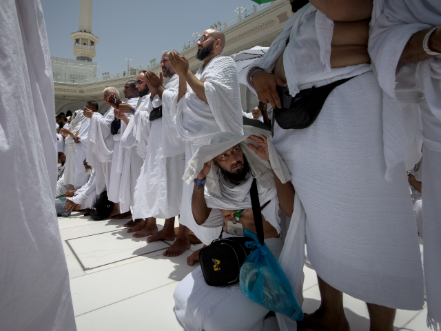 Muslim pilgrims pray in front of the Kaaba, the cubic building at the Grand Mosque, during