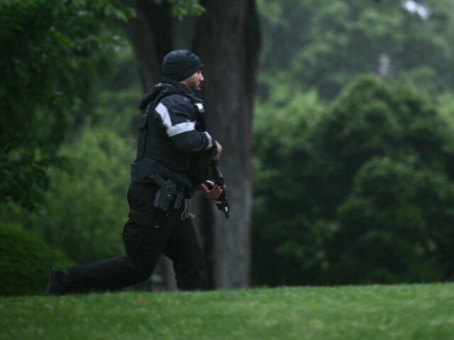 An armed Secret Service agent reacts at the White House in Washington, DC, after gunshots