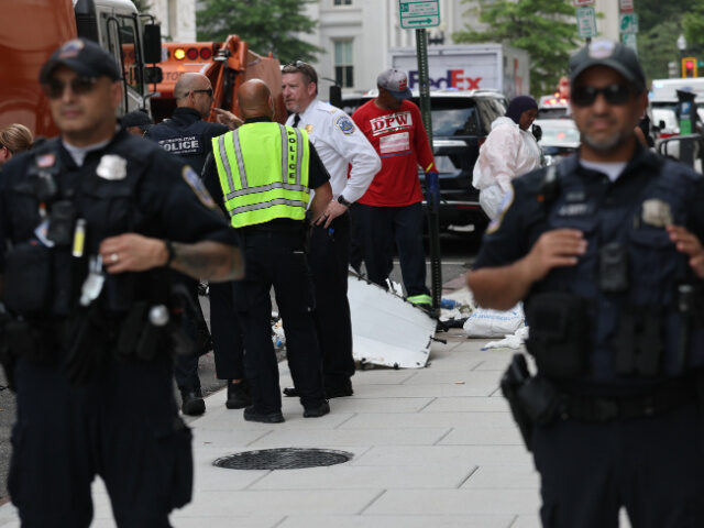 City workers, accompanied by DC Metropolitan Police clear a small homeless encampment near