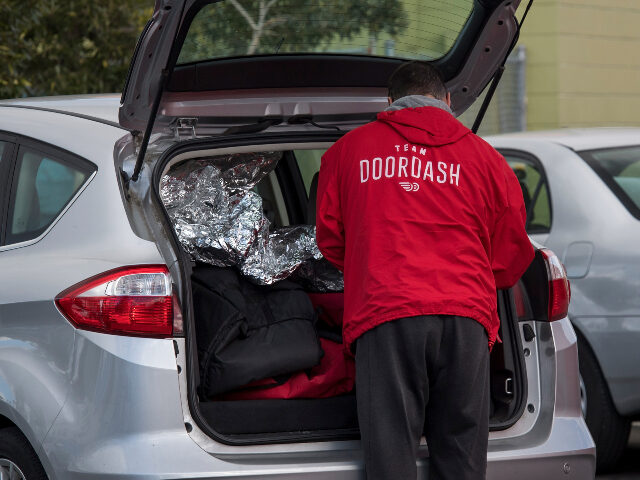 DoorDash driver A DoorDash Inc. delivery person arranges an order in the back of a vehicle outside of a Do