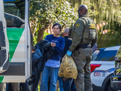 Multiple law enforcement officers processed a group of illegal migrants, mainly from China