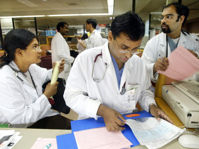 Doctors prepare paperwork in the physician consultation area of the emergency room at Cone