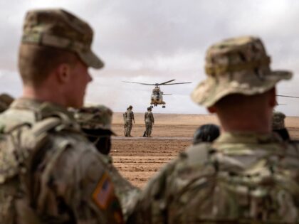 US army soldiers look on as a Royal Moroccan Air Force Aerospatiale SA 330 Puma takes off