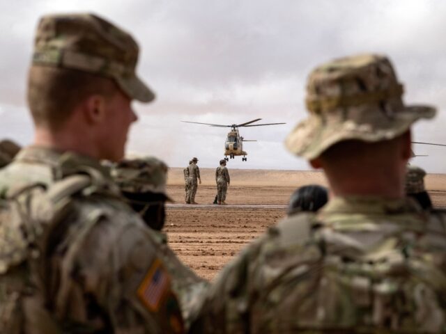 US army soldiers look on as a Royal Moroccan Air Force Aerospatiale SA 330 Puma takes off