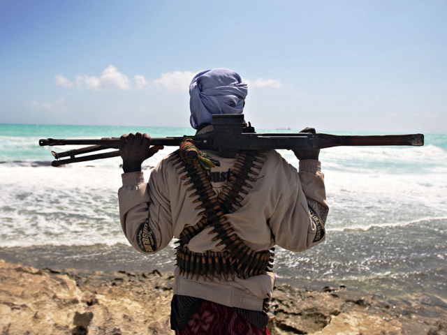 January 7, 2010 shows an armed pirate keeping vigil along the coastline at Hobyo town, nor