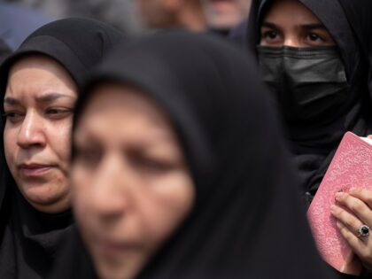 A veiled Iranian worshipper holds a copy of Muslims holy book of Koran during a protest ag