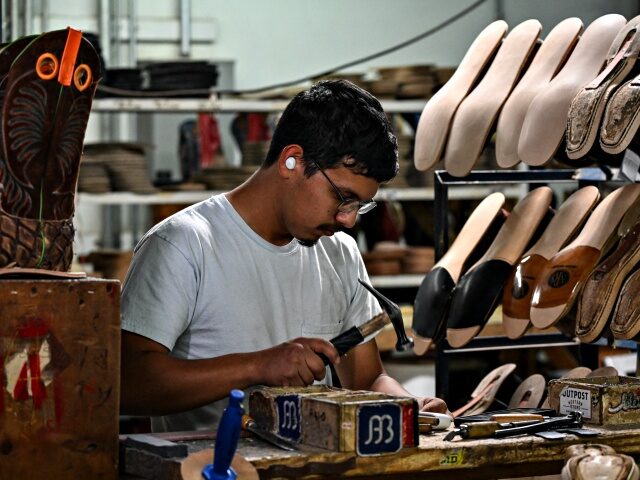 US-SAFRICA-TRADE-TARIFF-AGRICULTURE-FASHION A worker at the Rio of Mercedes cowboy boot factory hammers the sole of a shoe on July 31,