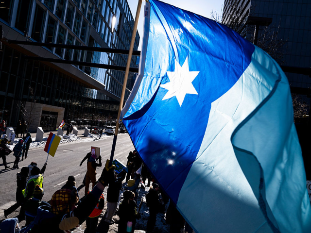 MINNEAPOLIS, MINNESOTA - JANUARY 30: A protester waves a Minnesota flag as part of a "Nati