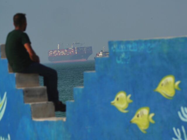 QESHM ISLAND, IRAN - APRIL 28: A Cargo boat navigates the sea behind a mural depicting fis